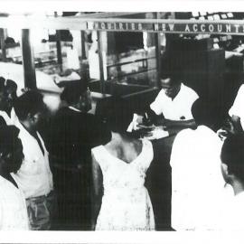 Port Moresby Branch premises, Territory of Papua New Guinea - Interior - Ginate Harry and Uru Lau, native staff attending to CSB enquiries 1959
