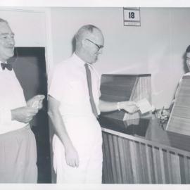 The Bank at Work - Branches - Port Moresby - Opening Day - Mr APJ Newman (Acting Treasurer & Director of Finance, Territory of Papua New Guinea) handing the 1st deposit to teller Brendan Kelly - 18 August 1960