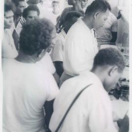 The Bank at Work - Commonwealth Banking Corporation - Branches - Port Moresby - Native Messenger Rahe Mea assisting customers with Savings Bank withdrawals - March 1961