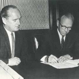 Premises - Melbourne - 60 Collins Street - Construction - Mr WM Leavey watching Dr HC Coombs sign the contract for construction - c.1960