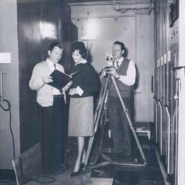 The Bank at work - Commonwealth Bank Head Office cnr. Pitt St and Martin Place - Archives repository area - Bob Thomas, Laurel McNeilly, and unknown person, filming - 1961